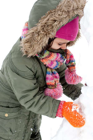 Happy little girl making a snowmanの写真素材