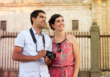 Attractive couple of tourists visiting the city and taking pictures of the monumentsの写真素材