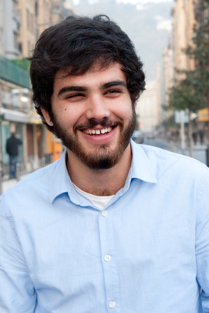 Portrait of handsome guy with beard laughing in the street