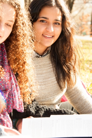 Teen girls studying outdoors in a sunny dayの写真素材