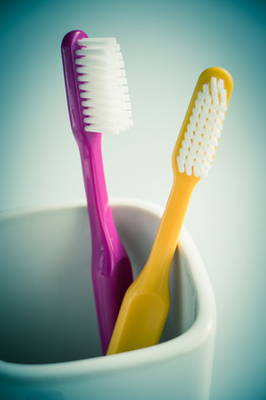 Colorful toothbrushes in a mugの写真素材