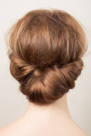 Rear view of the head of a young redhead woman with a bunの写真素材