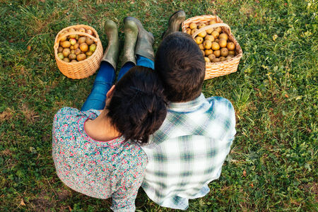 Loving couple sitting on the grass in autumn after picking apples. Top viewの写真素材