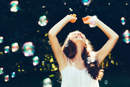 Young woman having fun with bubbles outdoorsの写真素材