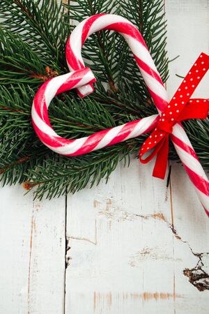 Love Christmas concept with a branch of fir and candy canes making a heart shapeの写真素材