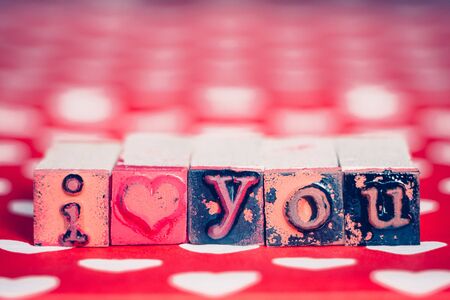 I love you message with rubber stamp letter blocks on a red and white hearts surface