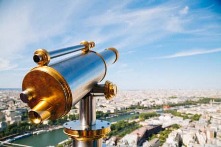 Telescope in the top floor of the Eiffel Tower and cityscape of Paris in a sunny day