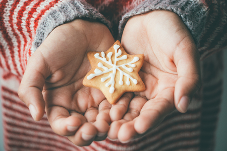 Decorated Christmas cookie in child handsの写真素材