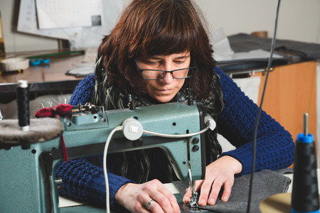 Seamstress sewing with a professional sewing machineの写真素材