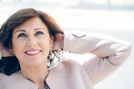 Portrait of a beautiful and smart business woman taking a break outdoors with arms behind her head
