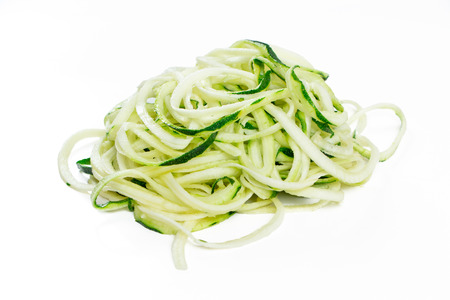 Raw zucchini noodles in a stack isolated on whiteの写真素材