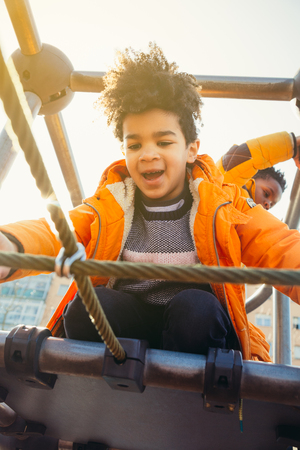 Happy children climbing in a urban playground construction in a sunny dayの写真素材