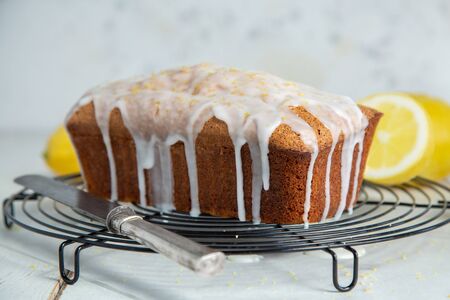Glazed lemon pound cake loaf with poppy seed and lemon zest on a cooling rackの写真素材