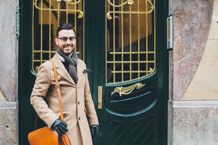 Portrait of a young businessman in a dandy style fashion at the front door