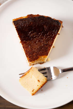 Portion of the traditional basque burnt cheesecake on a plate ready to eatの写真素材