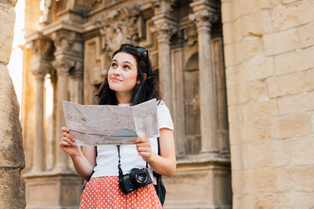 Young tourist woman visiting the old town in an european city with a mapの写真素材
