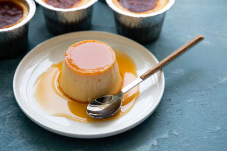Homemade flan or creme caramel on a blue rough backgroundの写真素材