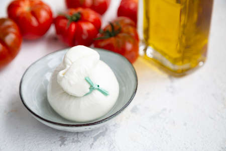 Burrata cheese, tomatoes and olive oil to make a traditional italian salad. Soft focusの写真素材