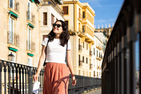 Young happy tourist woman with sunglasses visiting the Old Town in Donostia, Spain, in summerの写真素材