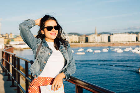 Happy young tourist woman ejoying the view of "la Concha bay" from the port in San Sebastian, Spainの写真素材
