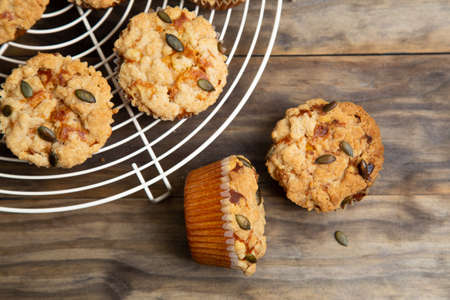 Pumpkin muffins with crumble and seeds topping on a rustic wooden tableの写真素材