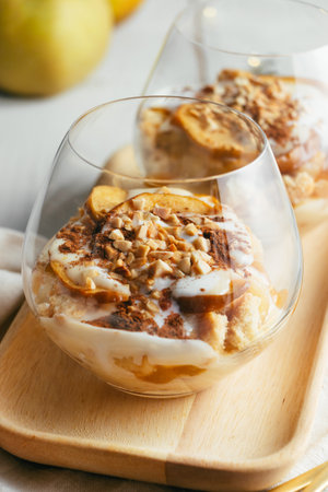 Christmas or autumn dessert in glasses made up of baked apple, crunchy almond cookies, custard, jam, yogurt, cinnamon, and toasted almonds. Parfaitの写真素材