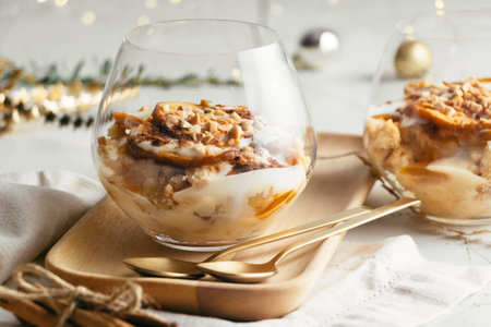 Christmas dessert in glasses made up of baked apple, crunchy almond cookies, custard, jam, yogurt, cinnamon, and toasted almonds. Parfaitの写真素材
