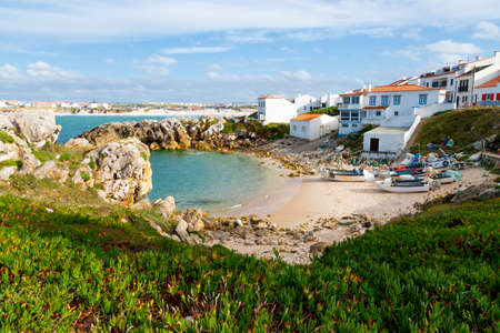 Beautiful fishermen creek with the fishing boats on the sand and Baleal beach at the backround in Penicheの写真素材