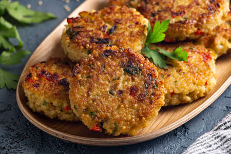 Gluten free vegetarian millet and vegetable burgers in a wooden plateの写真素材