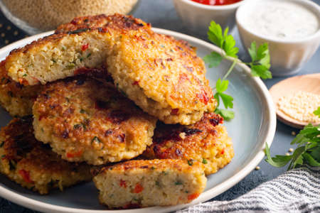 Gluten free vegetarian millet and vegetable burgers served with tomato and yogurt sauceの写真素材