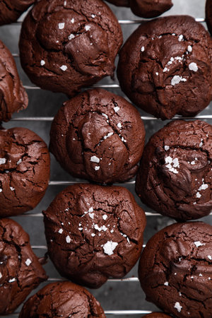 Top view of homemade brownie cookies with cracked top and sprinkled salt flakes on the cooling rackの写真素材