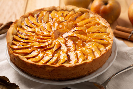 Homemade traditional apple cake with pastry cream filling and jam cover, a classic autumn or winter dessert or snackの写真素材