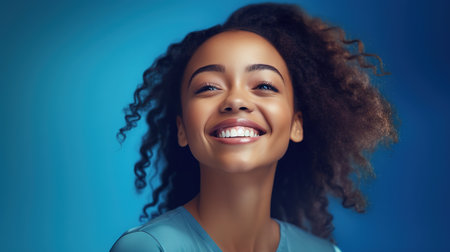 Beautiful african american woman with afro hairstyle on blue backgroundの素材