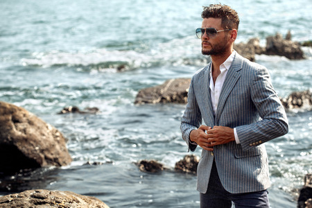 Man in elegant suite posing in rock backgroundの写真素材