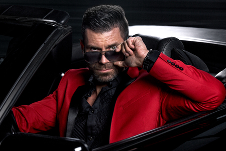 Portrait of handsome brutal man in the carの写真素材