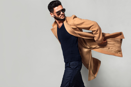 Elegant young handsome main coat wearing glasses. Studio fashion portrait.の写真素材