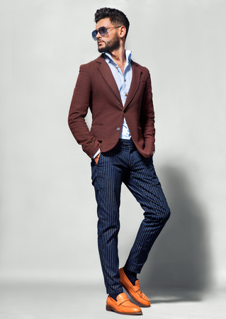 Elegant young handsome man in suite wearing glasses. Studio fashion portrait.の写真素材