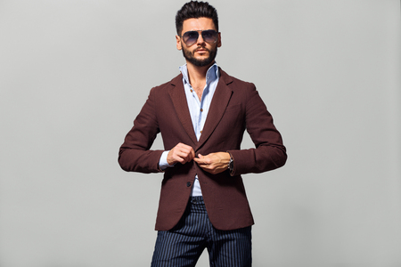 Elegant young handsome man in suite wearing glasses. Studio fashion portrait.の写真素材