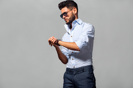 Elegant young handsome man in suite wearing glasses. Studio fashion portrait.の写真素材