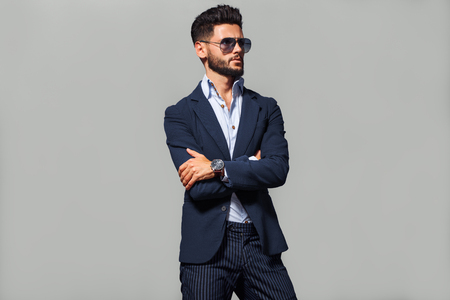 Elegant young handsome man in suite wearing glasses. Studio fashion portrait.の写真素材