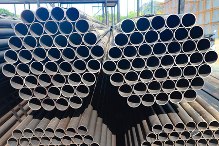 Metal and alumunium pipes heap in the cargo warehouse for transportation to the factory