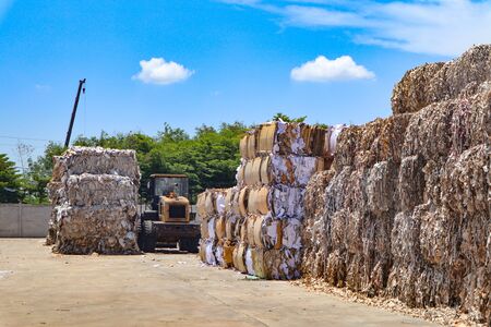 Recycle industry cardboard garbage and paper waste after pressing in hydraulic baling garbage press machine to a square dense for transportation to recycle factoryの写真素材