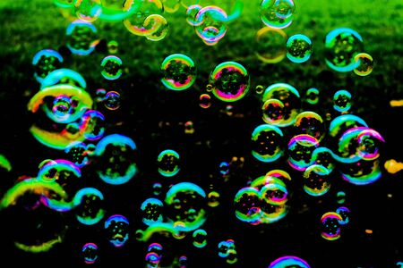 Beautiful abstract texture colorful pink and blue soap bubbles on the green and darkness background...