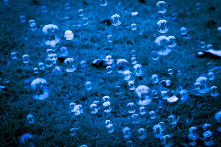 Beautiful abstract texture colorful pink and blue soap bubbles on the green and darkness background...