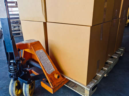 Shipment cartons box on pallets and wooden case on hand lift in interior warehouse cargo for export...