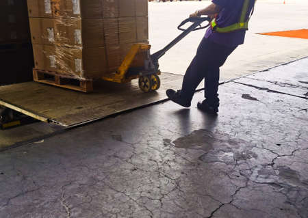Worker loading and unloading shipment carton boxes and goods on wooden pallet by forklift  from...