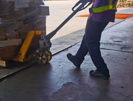 Worker loading and unloading shipment carton boxes and goods on wooden pallet by forklift  from...