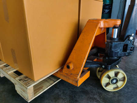 Shipment cartons box on pallets and wooden case on hand lift in interior warehouse cargo for export and sorting goods in freight logistics and transportation industrialの写真素材