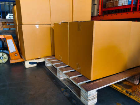 Shipment cartons box on pallets and wooden case on hand lift in interior warehouse cargo for export...
