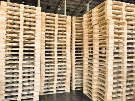 Worker driving forklift to loading and unloading wooden pallets from truck to warehouse cargo...